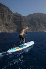 Moai 10'6 SUP board op zee met golven en blauwe lucht